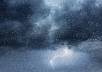 This intense weather scene captures the raw power of nature with storm clouds billowing across an overcast sky, heavy rainfall, and flashes of lightning illuminating the dark atmosphere. The dramatic, moody sky and cascading raindrops evoke a sense of powerful energy and impending force, perfect for visualizing extreme weather conditions. The composition showcases a blend of ominous clouds and heavy rain, ideal for projects focusing on nature, meteorology, or environmental themes.