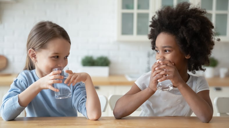 Two little girls drinking water