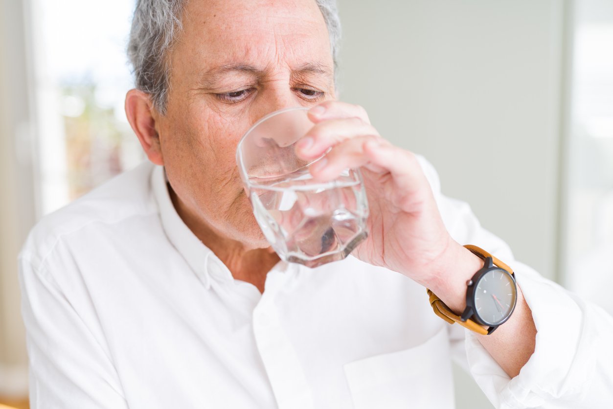 Photo of older man drinking a glass of water