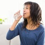 Casual smiling woman drinking filtered water