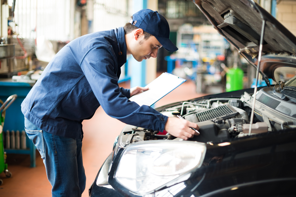 auto technician looking at car engine demonstrating the importance of changing car engine filters