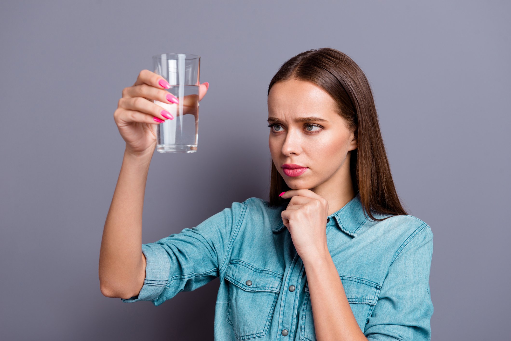woman looking at a glass of water for chloramine and chloroform