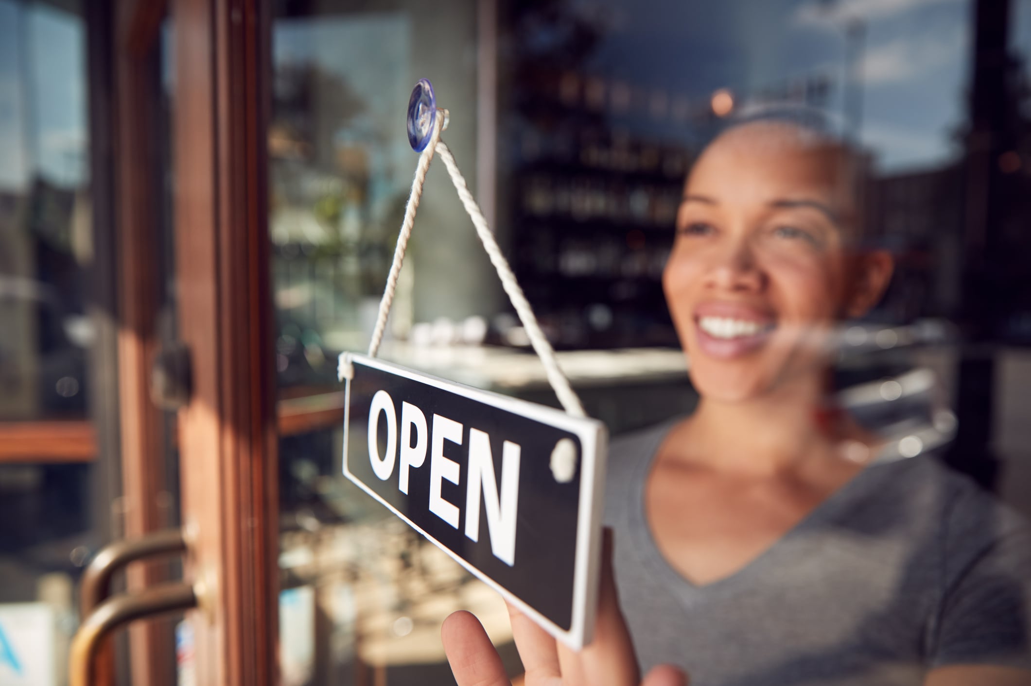 business woman at window with open sign