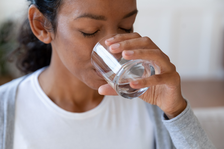 young woman drinking water close up