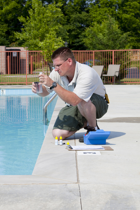 Service man checking chlorine, PH and other chemical levels in pool