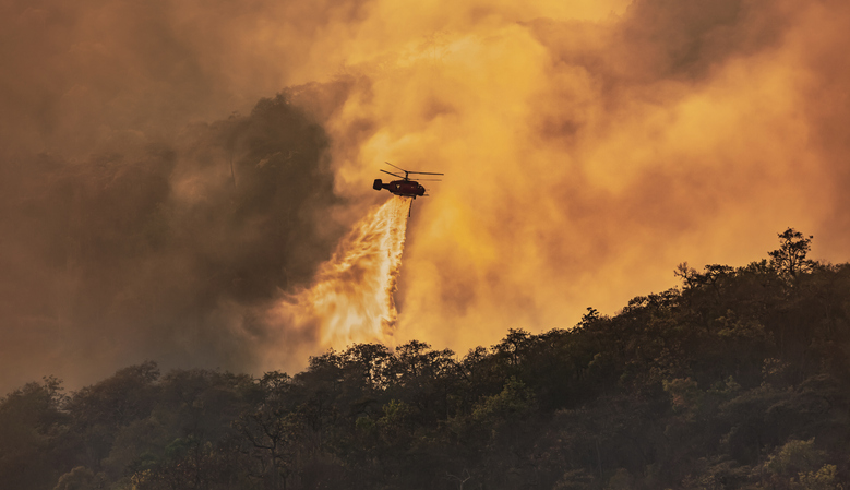 Helicopter dumping water on wildfire