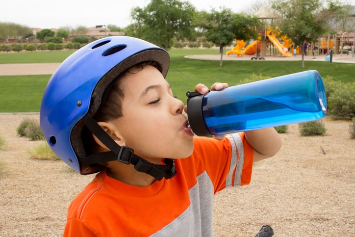 Young boy taking a break from riding his bike to rehydrate