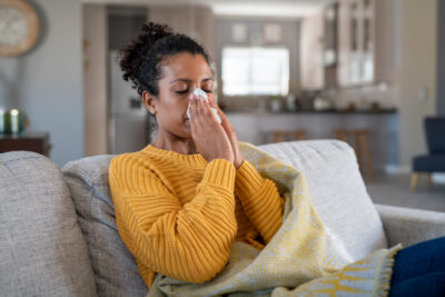Cold sick woman blowing nose illustrating the need for a higher MERV to help with allergies