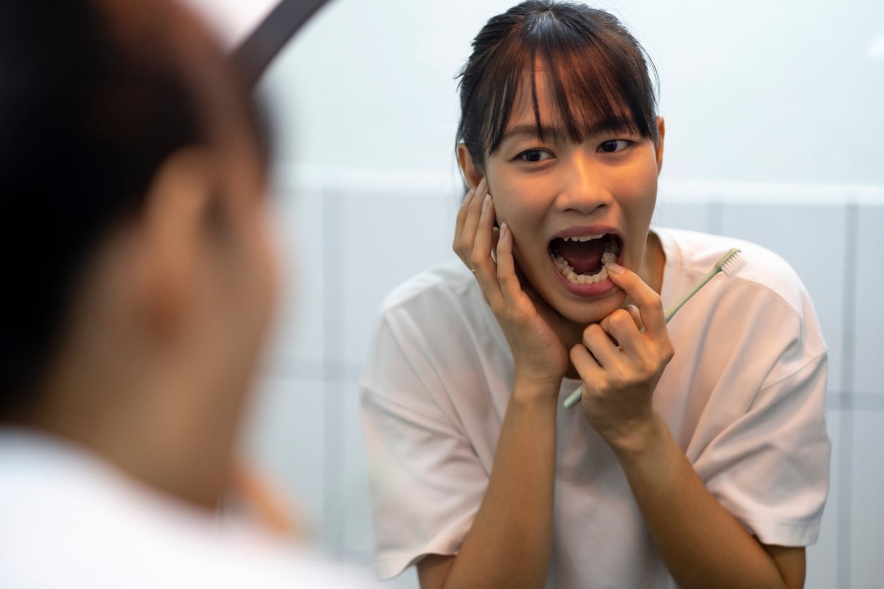 Young woman pointing at teeth 