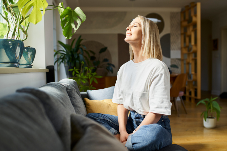 woman breathing clean air free of VOCs utilizing plants