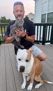 Picture of owner with cat and dog on porch