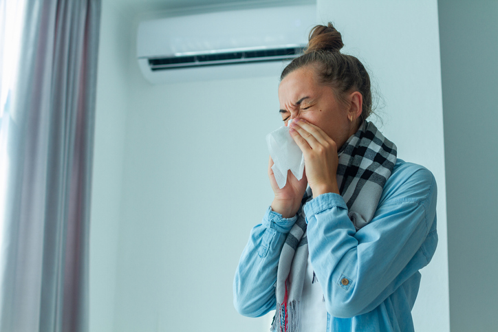 woman sneezing because of bad indoor air quality