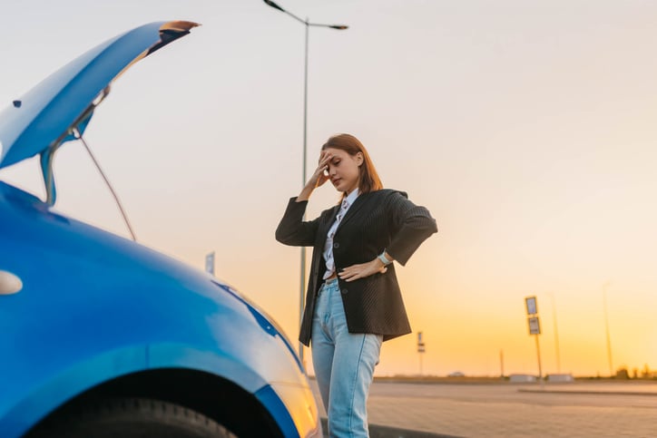 woman frustrated outside her car because she is trying to figure out the best air filter for car
